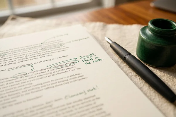 Interview transcript pages marked with pen annotations on a cream desk