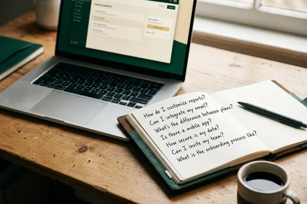 Notebook page listing real customer questions gathered from sales calls